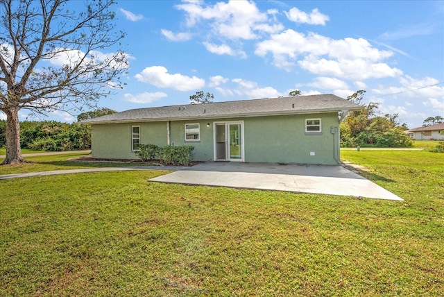 rear view of property featuring a lawn and a patio area