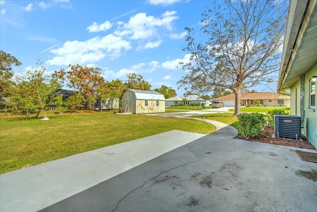 view of yard featuring central AC and a storage shed