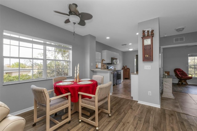 dining area with dark wood-type flooring and ceiling fan