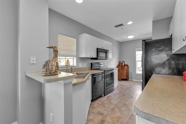 kitchen featuring white cabinets, stainless steel appliances, sink, and light tile patterned floors