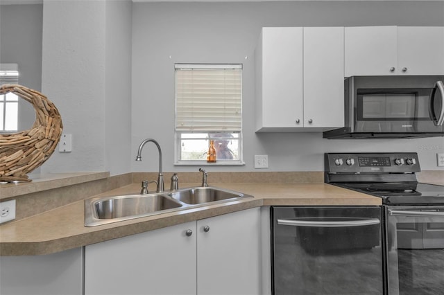 kitchen with white cabinets, appliances with stainless steel finishes, and sink