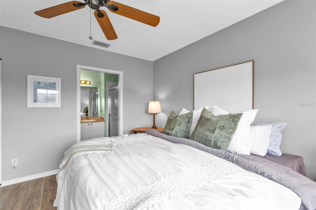 bedroom featuring dark wood-type flooring, ceiling fan, and connected bathroom