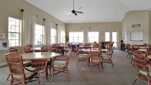 dining room with high vaulted ceiling, light carpet, and ceiling fan