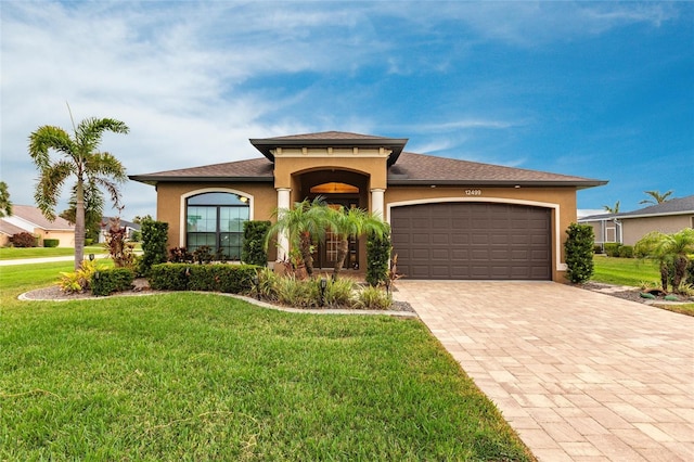 prairie-style house featuring a garage and a front yard