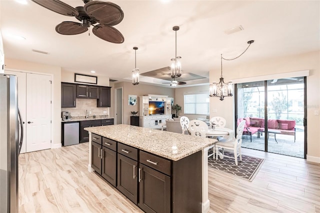 kitchen featuring dark brown cabinetry, appliances with stainless steel finishes, sink, and a kitchen island