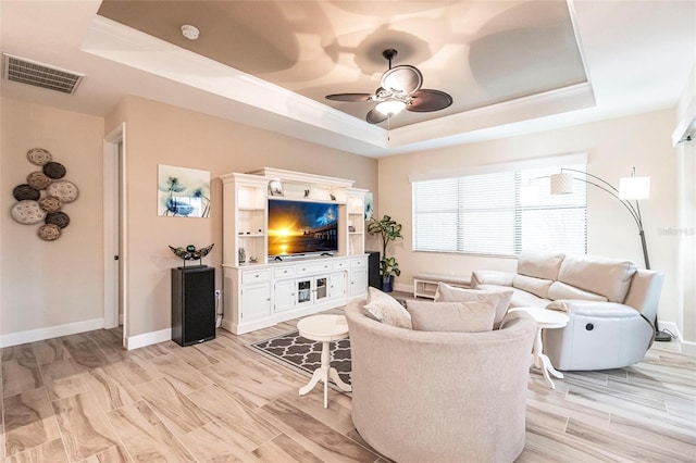 living room featuring a tray ceiling and ceiling fan