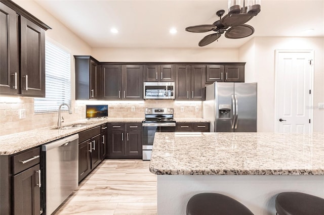 kitchen featuring a breakfast bar area, sink, dark brown cabinetry, and stainless steel appliances