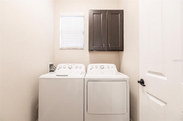 washroom with cabinets and washing machine and dryer