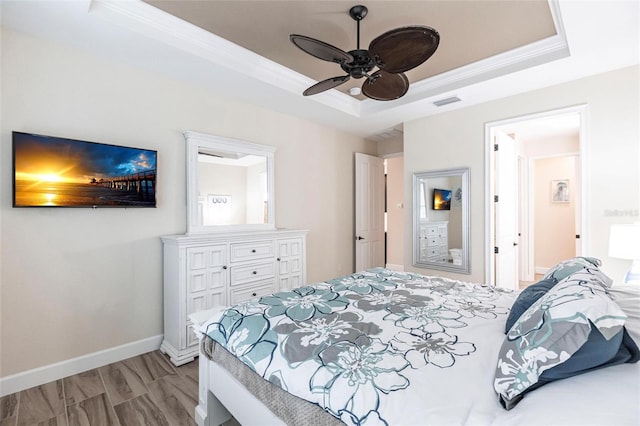 bedroom with ornamental molding, ceiling fan, and a raised ceiling