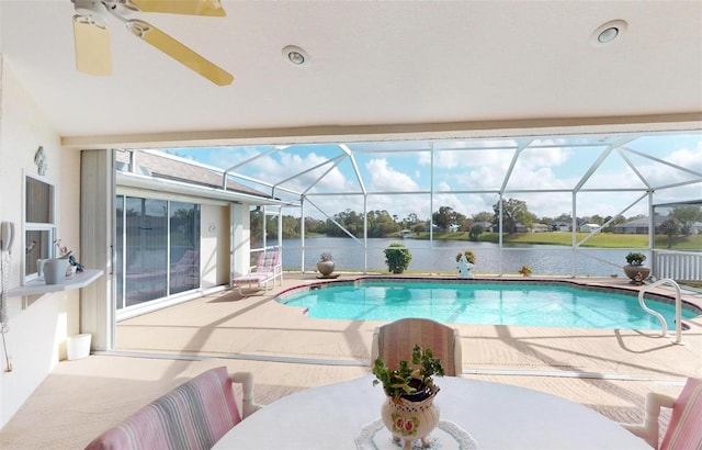 view of swimming pool featuring glass enclosure, a water view, and a patio