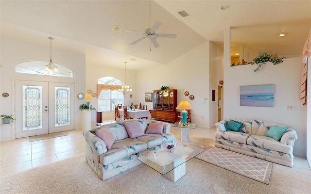 tiled living room with french doors, high vaulted ceiling, and ceiling fan with notable chandelier