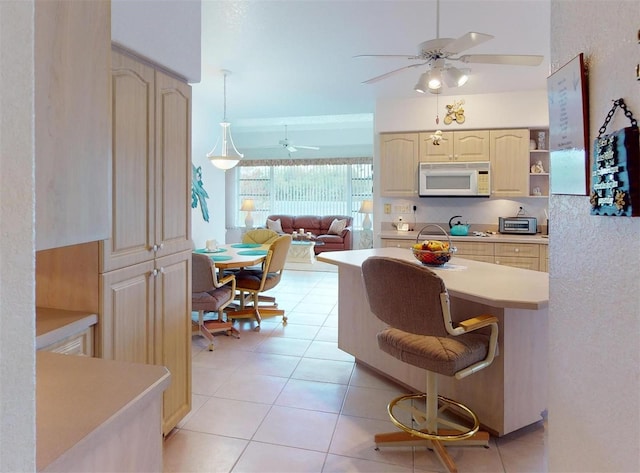 kitchen featuring cooktop, ceiling fan, light tile patterned flooring, and hanging light fixtures