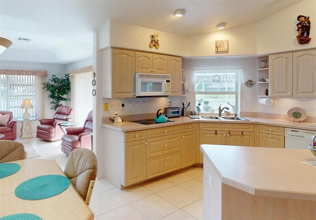 kitchen featuring white appliances, sink, and light brown cabinetry