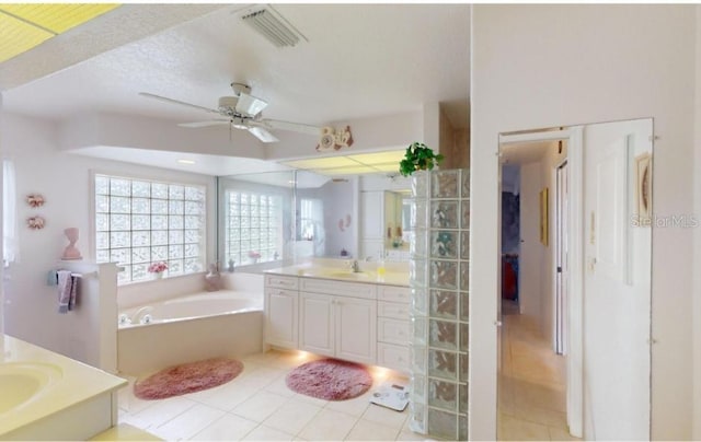 bathroom featuring tile patterned flooring, vanity, ceiling fan, and a tub to relax in