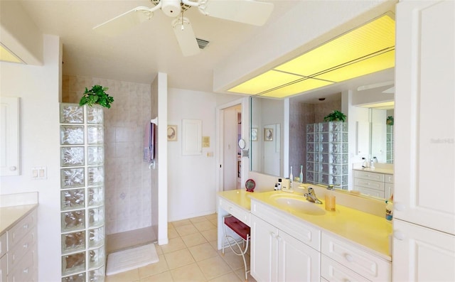 bathroom with a tile shower, vanity, tile patterned floors, and ceiling fan