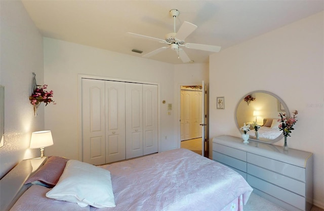 carpeted bedroom with ceiling fan and a closet