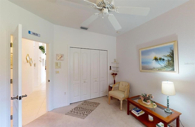 sitting room featuring light carpet and ceiling fan