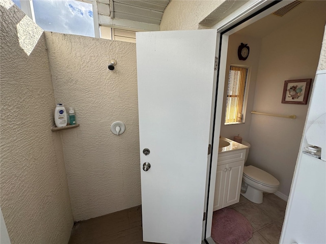 bathroom featuring tile patterned flooring, vanity, and toilet