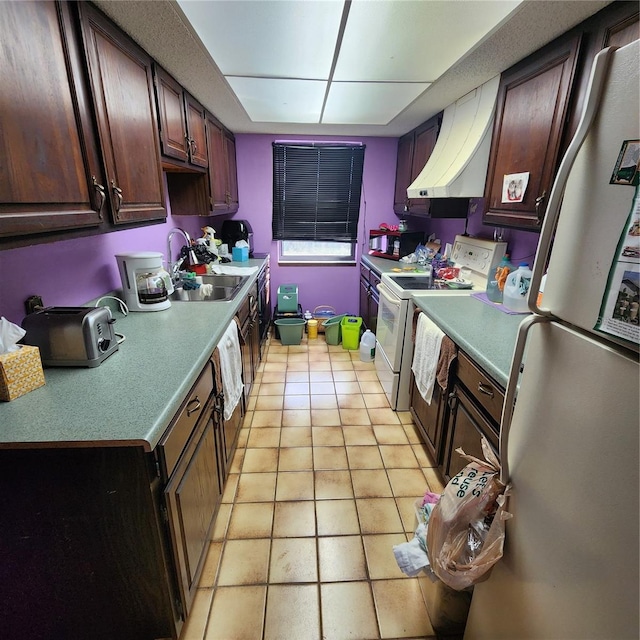 kitchen with dark brown cabinetry, light tile patterned flooring, stainless steel refrigerator, white electric range, and range hood