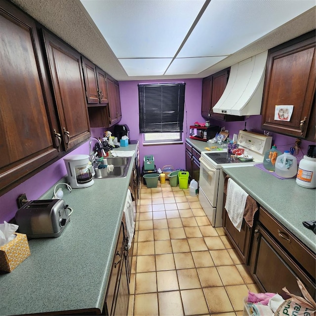 kitchen with light tile patterned flooring, sink, dark brown cabinets, range hood, and electric range