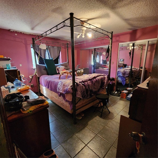 bedroom with a textured ceiling and dark tile patterned flooring