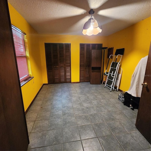 tiled spare room featuring a textured ceiling