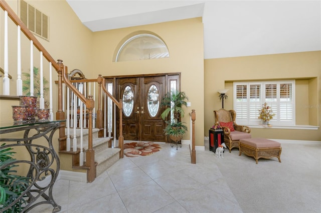 entryway featuring high vaulted ceiling, light carpet, and french doors