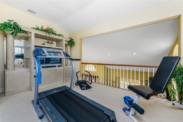 exercise room with lofted ceiling and carpet flooring