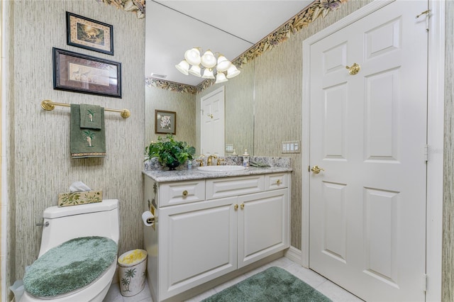 bathroom with toilet, vanity, and tile patterned floors