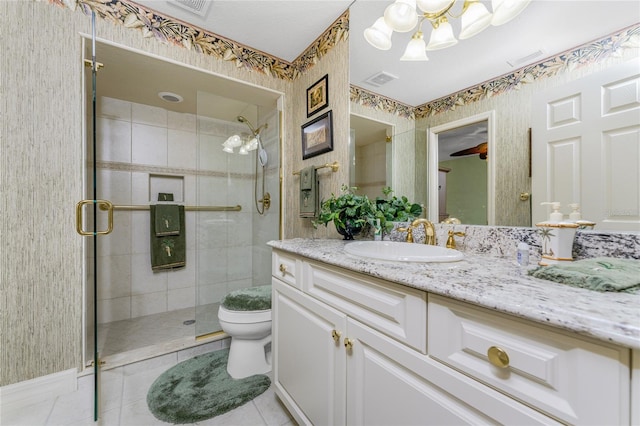 bathroom with toilet, vanity, tile patterned floors, and a shower with door