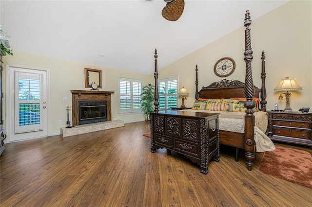 bedroom with a fireplace, dark hardwood / wood-style floors, multiple windows, and vaulted ceiling