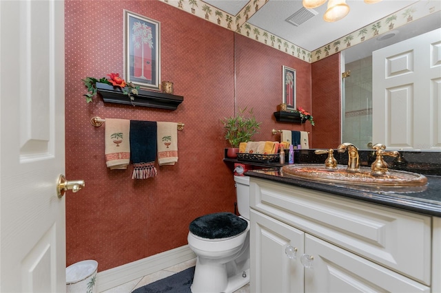 bathroom featuring tile patterned flooring, vanity, and toilet