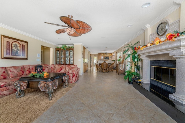 tiled living room with a fireplace, ceiling fan, and crown molding