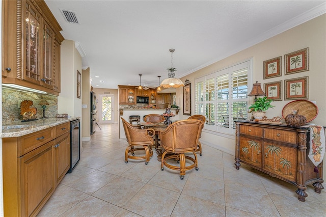 tiled dining room with beverage cooler and ornamental molding