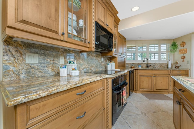 kitchen featuring light tile patterned floors, black appliances, sink, and light stone countertops