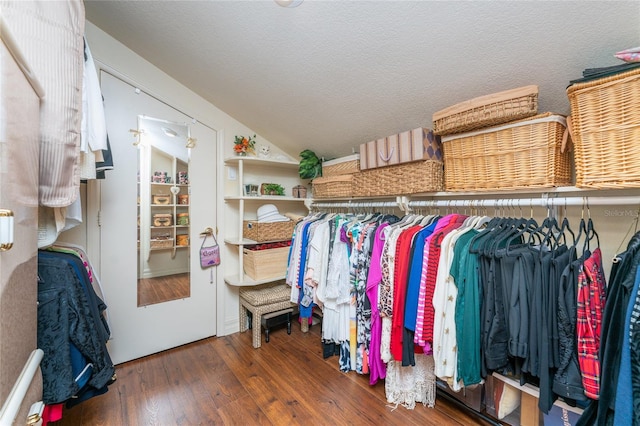 walk in closet with dark hardwood / wood-style floors and lofted ceiling