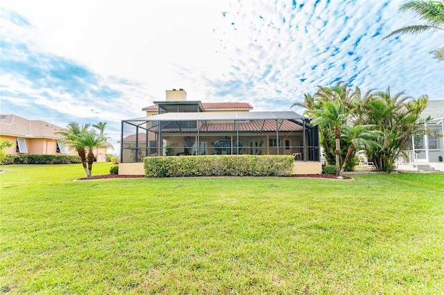 back of house with a yard and a lanai