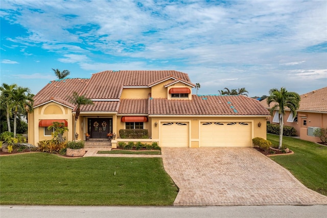 mediterranean / spanish house with a garage and a front yard