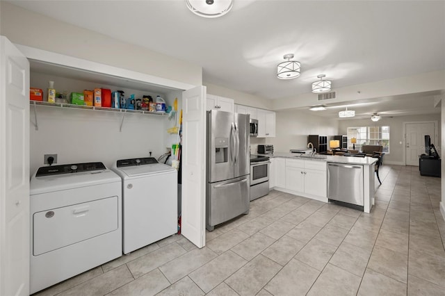 interior space featuring light tile patterned floors, washer and clothes dryer, sink, and ceiling fan