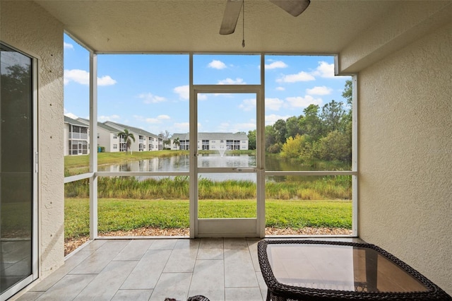 unfurnished sunroom featuring a water view and ceiling fan