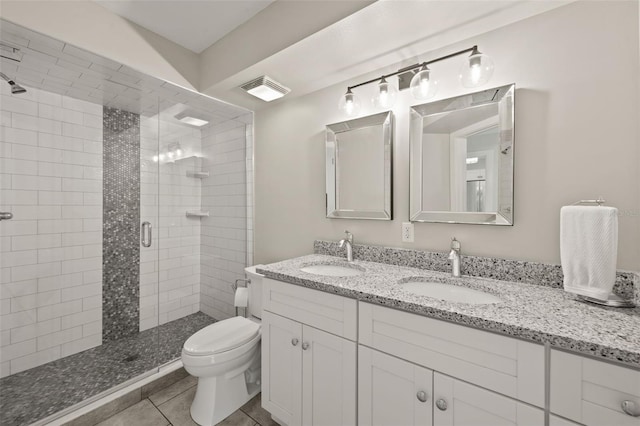 bathroom featuring tile patterned floors, vanity, toilet, and a shower with door