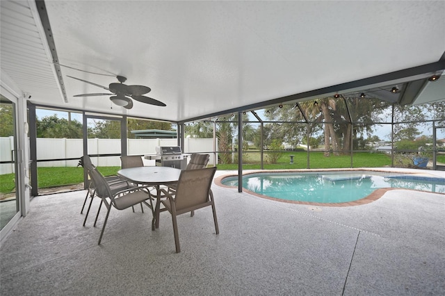 view of swimming pool featuring glass enclosure, a patio, ceiling fan, area for grilling, and a yard