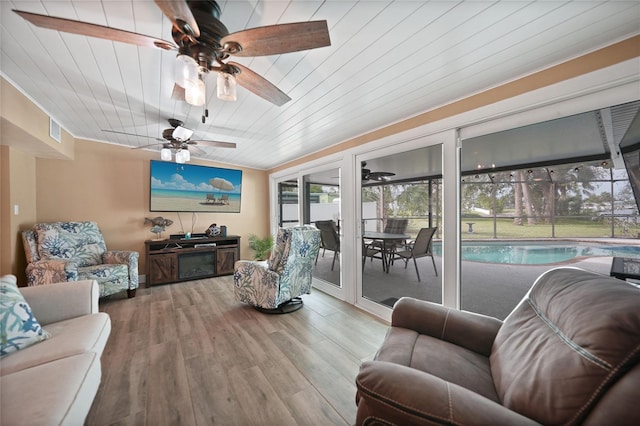 living room with wood-type flooring, a healthy amount of sunlight, ceiling fan, and wood ceiling