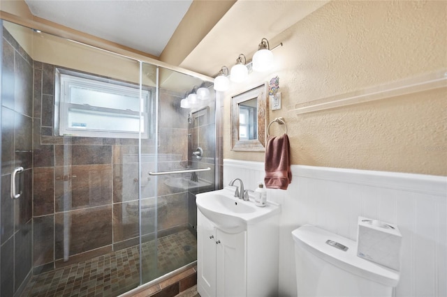 bathroom featuring toilet, wood walls, an enclosed shower, and vanity