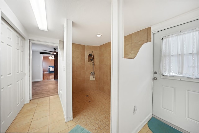 bathroom featuring tile patterned flooring, tiled shower, and ceiling fan