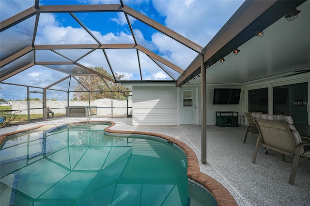 view of swimming pool with glass enclosure and a patio area