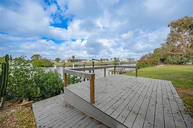 wooden terrace featuring a water view and a lawn