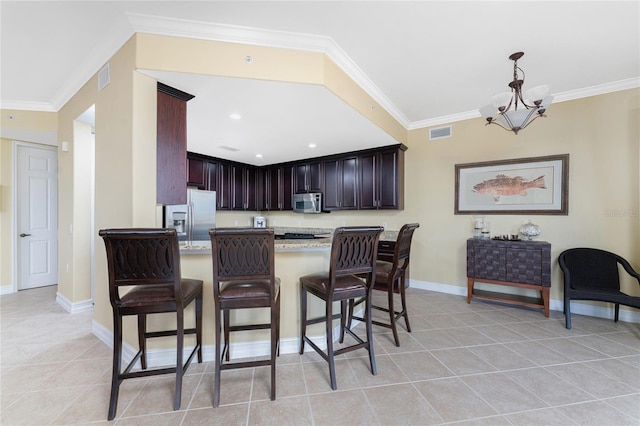 kitchen featuring an inviting chandelier, crown molding, light tile patterned flooring, kitchen peninsula, and stainless steel appliances