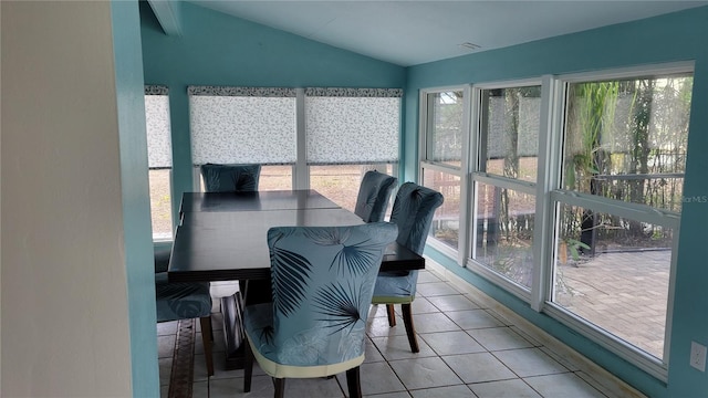 sunroom featuring vaulted ceiling and a healthy amount of sunlight