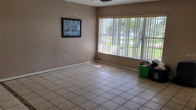 tiled empty room featuring ceiling fan